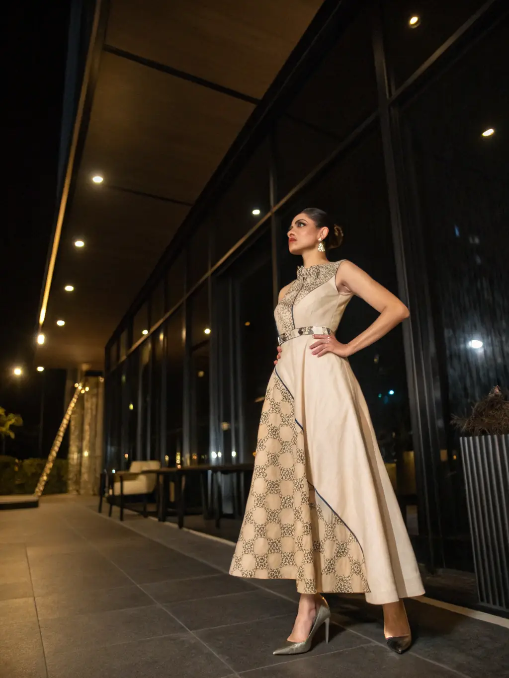 A model wearing a modern gown with a traditional Bikaneri touch, photographed in a studio setting.